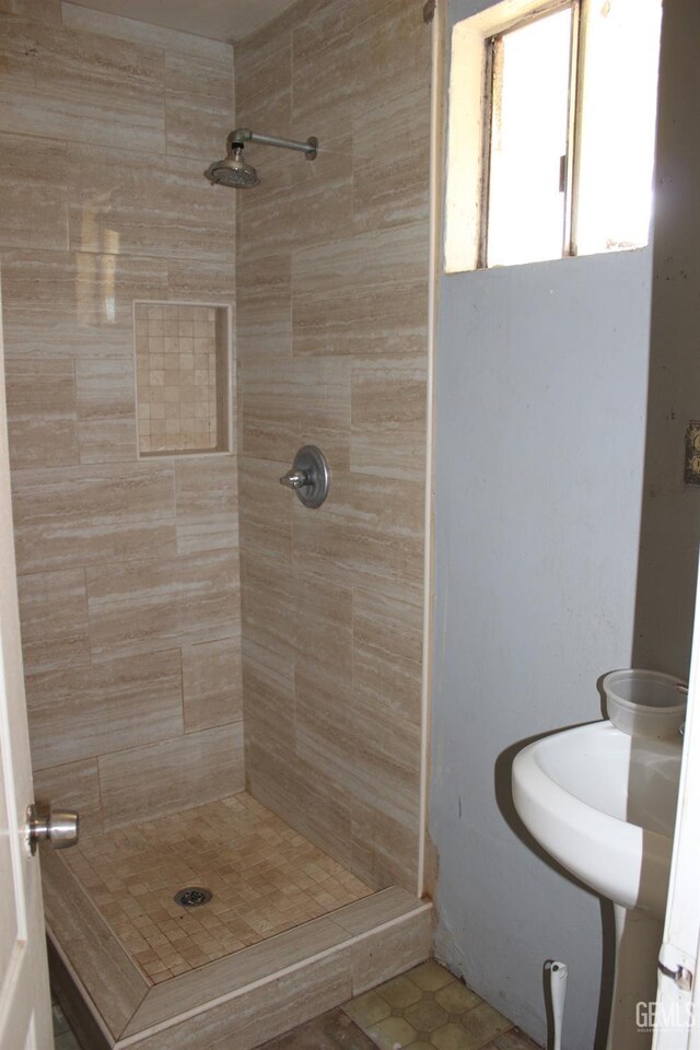 bathroom with tile patterned flooring and a tile shower