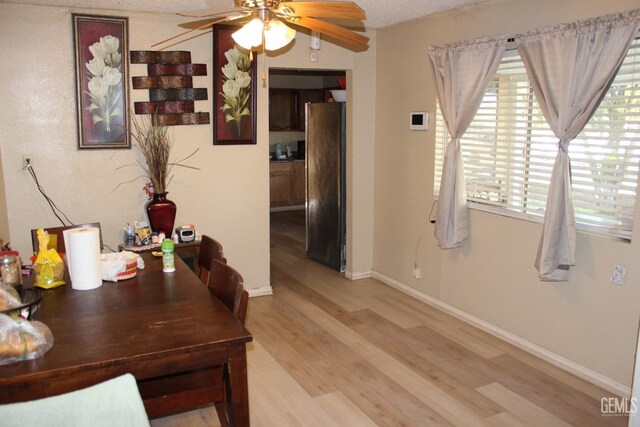 interior space with a textured ceiling, a wealth of natural light, and light hardwood / wood-style flooring