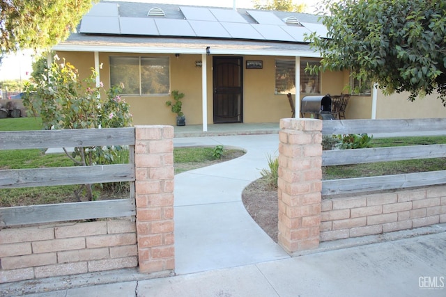 view of front of house with a porch and solar panels