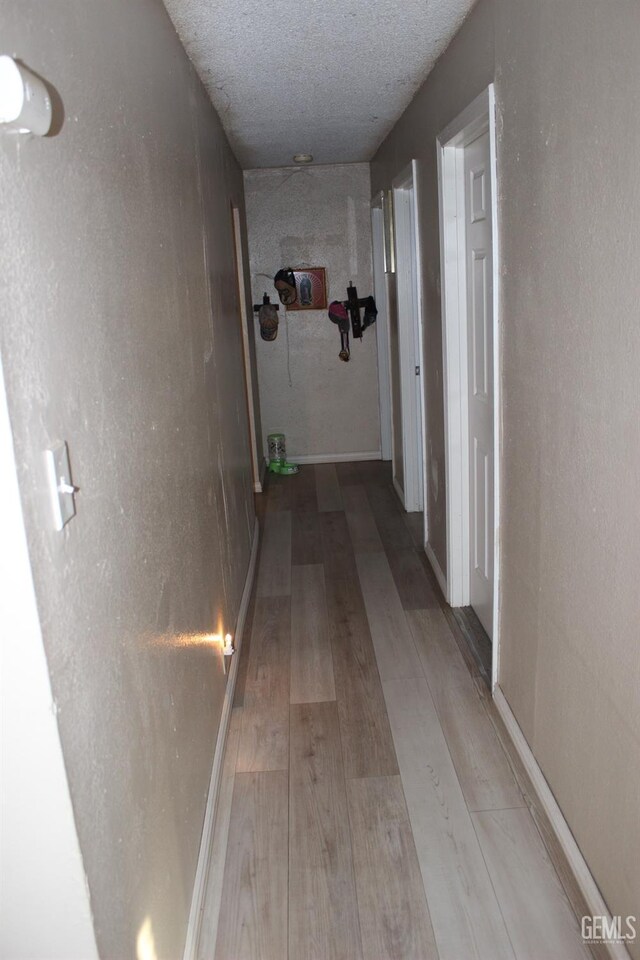 corridor featuring hardwood / wood-style flooring and a textured ceiling