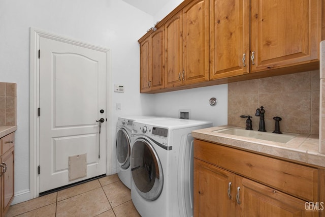 10834 Olcese Rd, Bakersfield, CA 93308 - clothes washing area featuring washer and dryer, sink, light tile patterned flooring, and cabinets