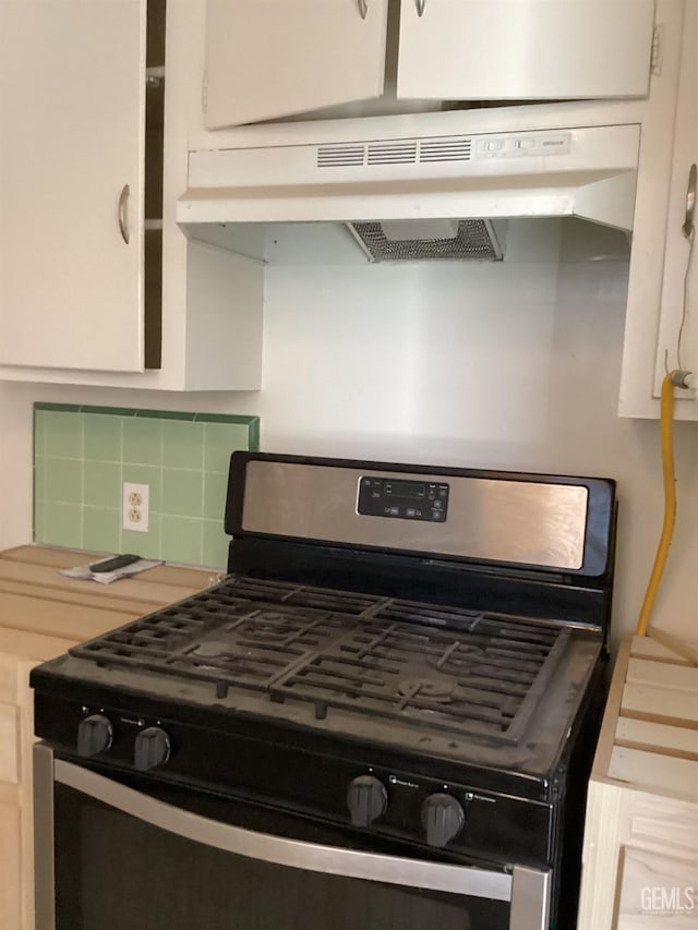 kitchen featuring decorative backsplash, white cabinetry, and stainless steel gas range oven