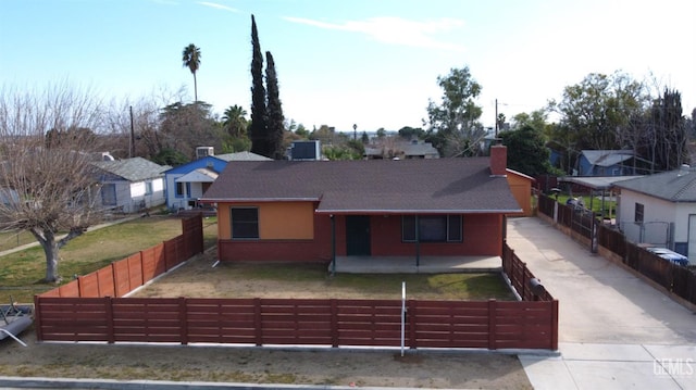 ranch-style home with a fenced front yard, a chimney, and a residential view