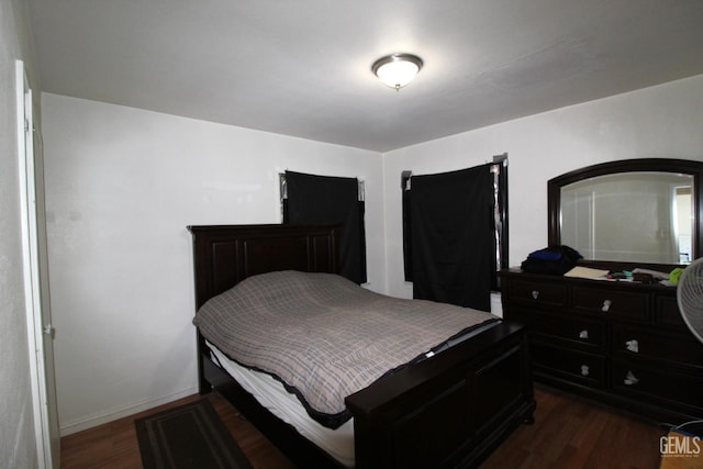 bedroom featuring baseboards and dark wood finished floors