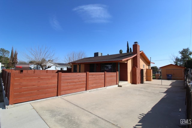 view of front of house featuring a fenced front yard, a gate, and a chimney