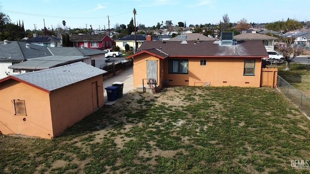 rear view of property featuring crawl space, a residential view, fence, and stucco siding