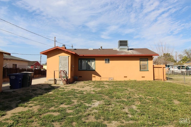 back of house with crawl space, fence, cooling unit, and stucco siding