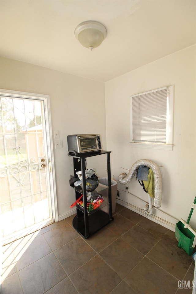 interior space with dark tile patterned floors and baseboards