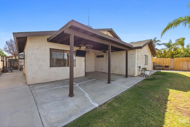 back of house with a patio area, ceiling fan, and a yard