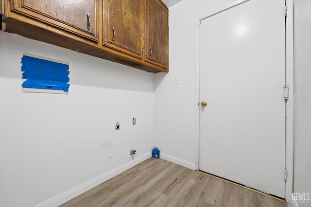 clothes washing area featuring light hardwood / wood-style floors, hookup for a gas dryer, cabinets, and hookup for an electric dryer