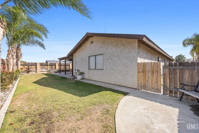 view of side of property with a lawn and a patio