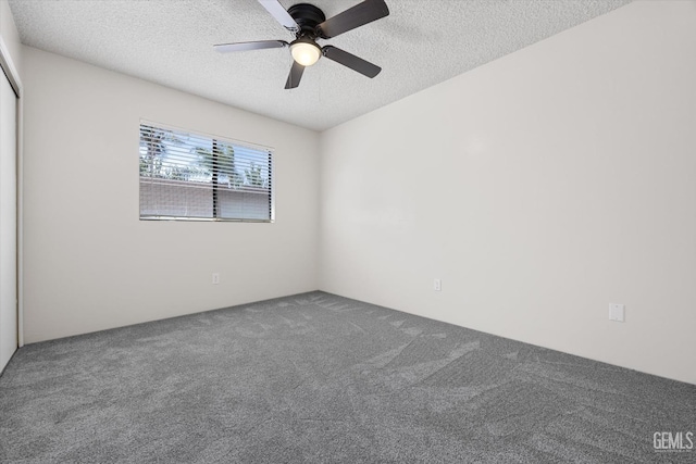 spare room featuring carpet flooring, ceiling fan, and a textured ceiling