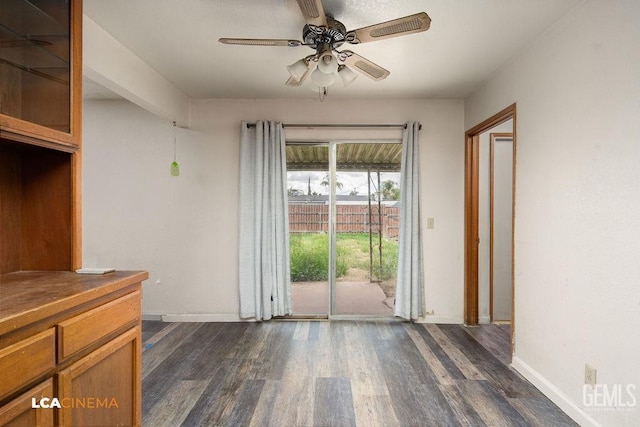 interior space featuring dark wood-type flooring, baseboards, and a ceiling fan