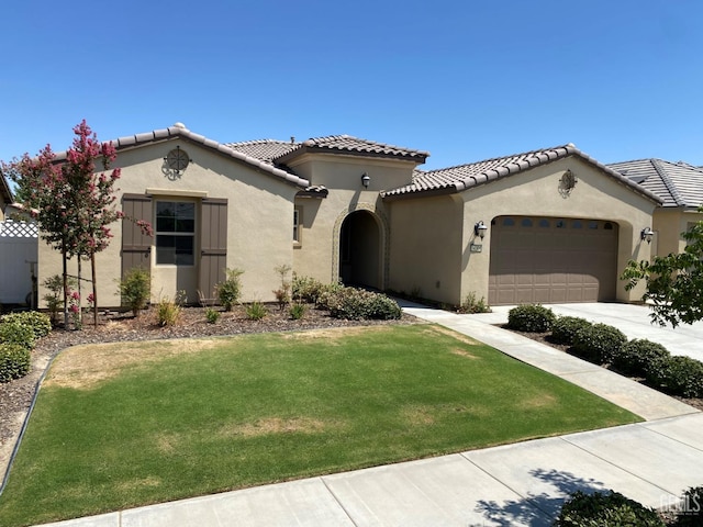 mediterranean / spanish house featuring a garage and a front lawn