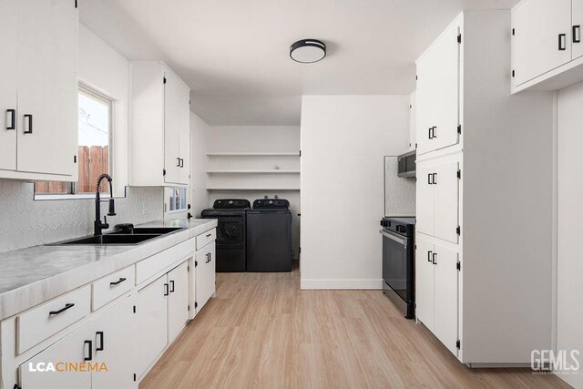 417 B St, Taft, CA 93268 - kitchen with independent washer and dryer, light wood-style flooring, stove, tasteful backsplash, and white cabinetry