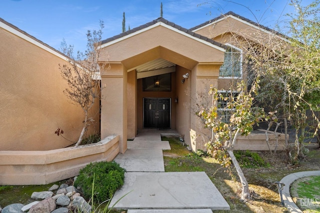 view of exterior entry featuring stucco siding