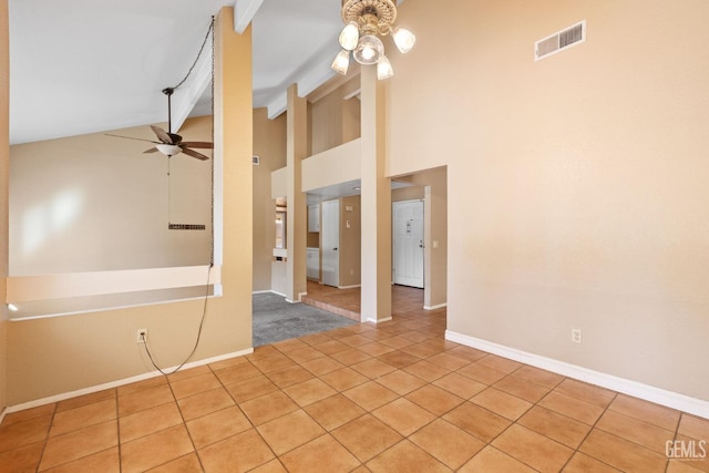 unfurnished room with light tile patterned floors, visible vents, ceiling fan, high vaulted ceiling, and baseboards