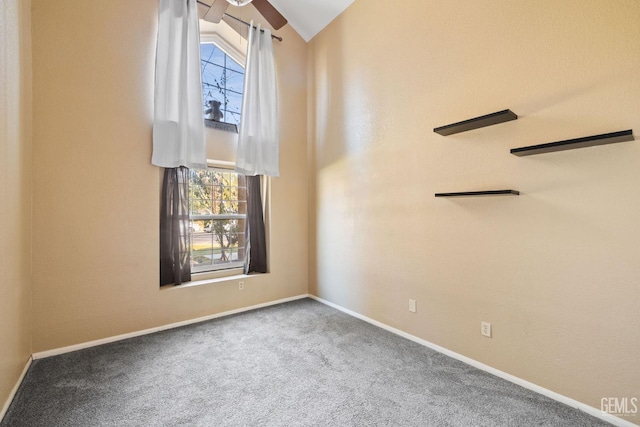 spare room with carpet floors, high vaulted ceiling, a ceiling fan, and baseboards