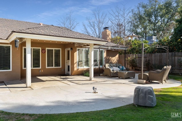 rear view of house with a patio, fence, an outdoor living space, and stucco siding