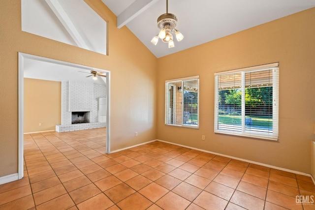 empty room with ceiling fan, light tile patterned floors, a fireplace, baseboards, and beamed ceiling