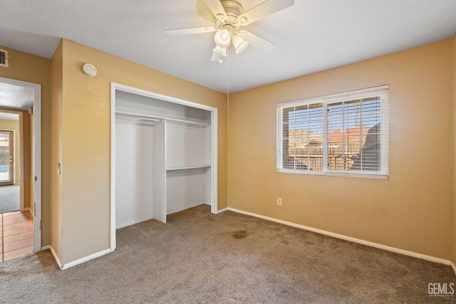 unfurnished bedroom with carpet floors, multiple windows, and a closet