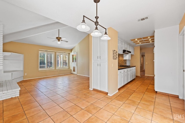 kitchen with dark countertops, visible vents, white cabinetry, and decorative light fixtures