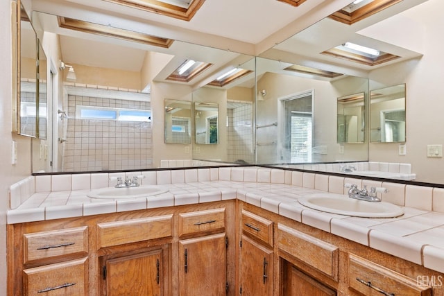 full bathroom featuring a sink, double vanity, and tiled shower