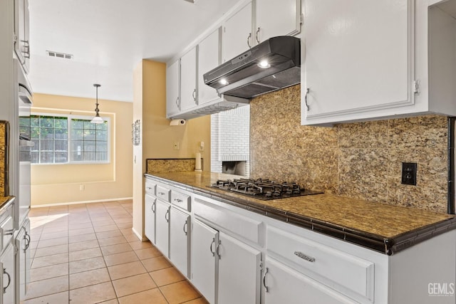 kitchen featuring decorative light fixtures, dark countertops, backsplash, white cabinets, and under cabinet range hood