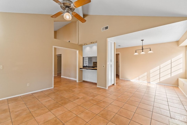 unfurnished living room with light tile patterned floors, ceiling fan, lofted ceiling, visible vents, and baseboards