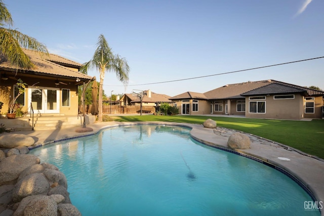 view of pool with a patio area and a lawn