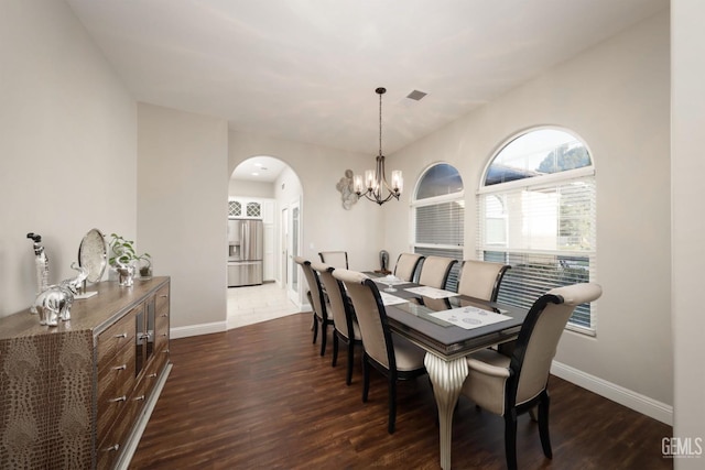 dining room with dark wood-type flooring and a chandelier