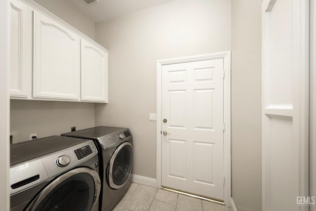 laundry area featuring cabinets, washer and dryer, and light tile patterned floors