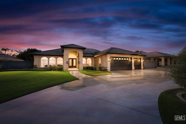 view of front of property with a yard, a garage, and solar panels