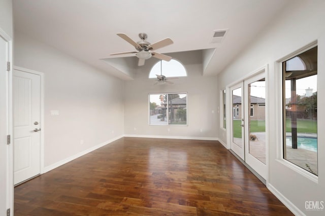 spare room featuring dark hardwood / wood-style flooring, a wealth of natural light, and ceiling fan