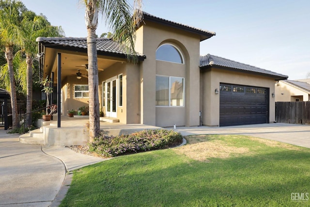 mediterranean / spanish-style house with a garage, a front lawn, and ceiling fan