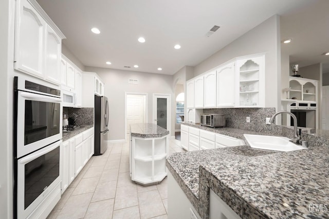 kitchen with stainless steel appliances, sink, white cabinets, and decorative backsplash