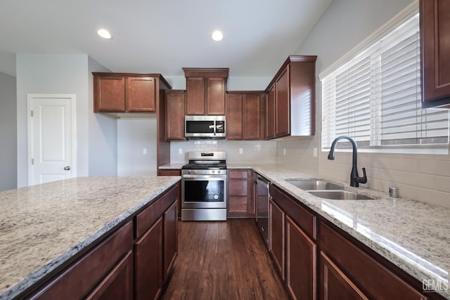 5817 Neutra Dr, Bakersfield, CA 93311 - kitchen with appliances with stainless steel finishes, dark wood finished floors, tasteful backsplash, light stone countertops, and recessed lighting