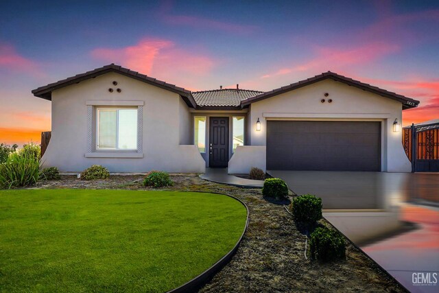 5817 Neutra Dr, Bakersfield, CA 93311 - view of front facade featuring driveway, an attached garage, stucco siding, a front yard, and a tile roof