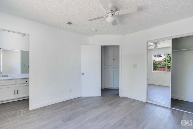 1857 Fern Tree Close, Wasco, CA 93280 - unfurnished bedroom featuring light wood-type flooring, a textured ceiling, ceiling fan, and connected bathroom