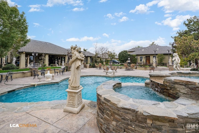 view of swimming pool featuring a pool with connected hot tub and a patio area