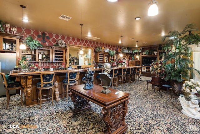 interior space with visible vents, a community bar, and wallpapered walls