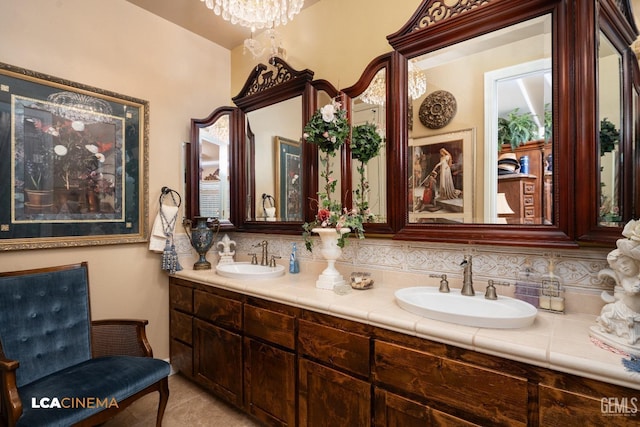 bathroom with a chandelier, a sink, and double vanity