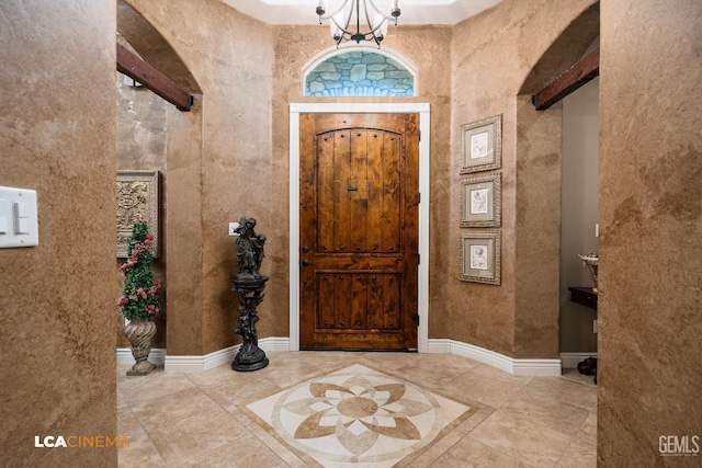 foyer featuring baseboards and an inviting chandelier