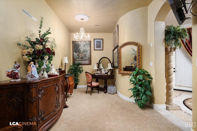 interior space with arched walkways, a notable chandelier, light colored carpet, visible vents, and baseboards