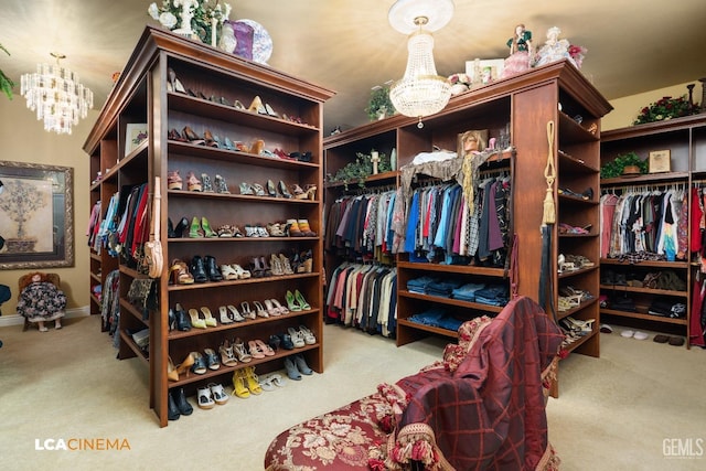 spacious closet with light colored carpet and a notable chandelier