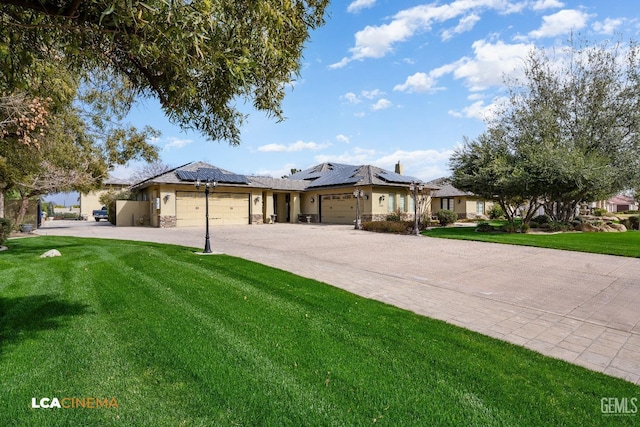 ranch-style house featuring a garage, decorative driveway, a front lawn, and solar panels