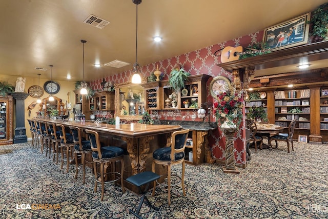 bar with wallpapered walls, visible vents, pendant lighting, and carpet flooring