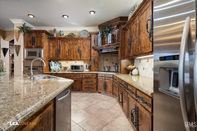 kitchen featuring appliances with stainless steel finishes, backsplash, a sink, and ornamental molding