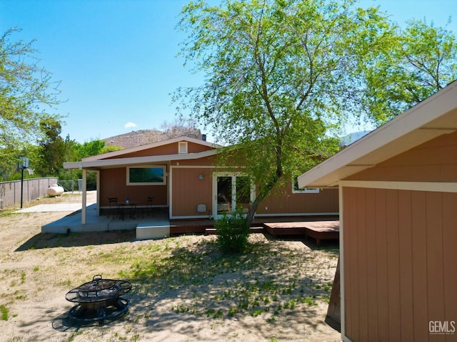 back of property featuring an outdoor fire pit and a patio area