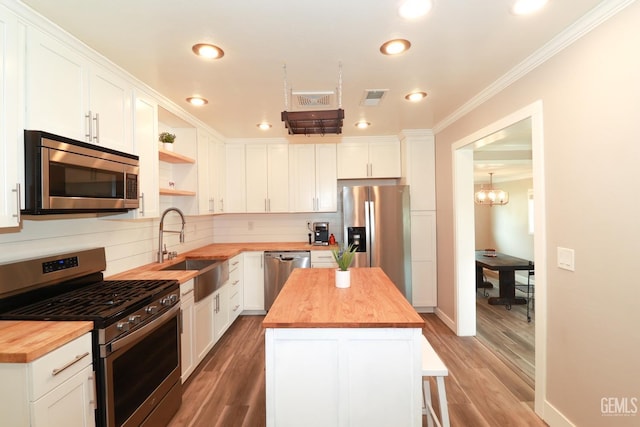 kitchen with white cabinets, wooden counters, and appliances with stainless steel finishes